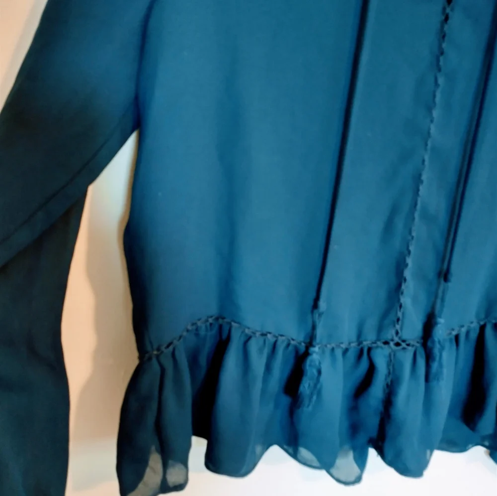Ana blue long sleeve tunic with peplum detail near the hem and drawstrings at th